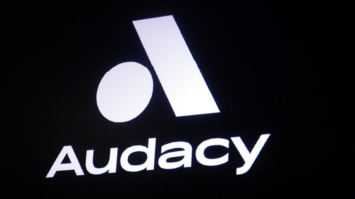 A screen displays the company logo for Audacy, Inc. on the floor of the New York Stock Exchange (NYSE) in New York City, U.S., May 16, 2023.