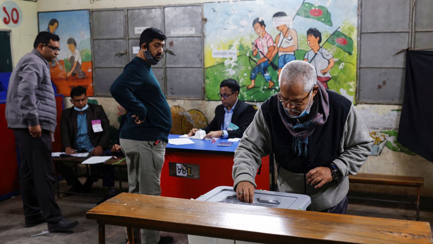 An elderly man puts ballot paper inside a box after casting vote during the 12th general election in Dhaka, Bangladesh, January 7, 2024. REUTERS/Mohammad Ponir Hossain
