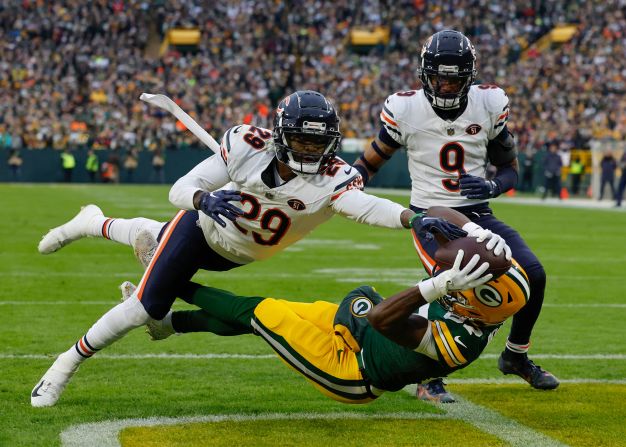 Green Bay Packers wide receiver Romeo Doubs can't quite pull in the catch while being defended by Chicago Bears cornerback Tyrique Stevenson on January 7. The Packers won 17-9 to clinch a playoff spot.