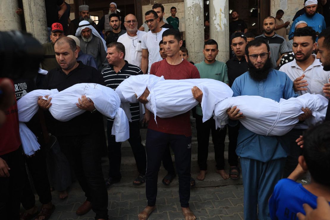 Relatives carry the bodies of children from the Abu Quta family who were killed in Israeli strikes on the Palestinian city of Rafah in the southern Gaza Strip, during their funeral on October 8, 2023.