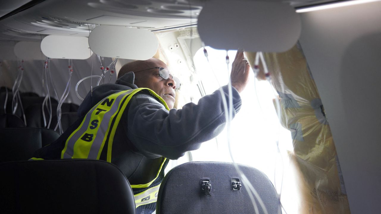 National Transportation Safety Board (NTSB) Investigator-in-Charge John Lovell examines the fuselage plug area of Alaska Airlines Flight 1282 Boeing 737-9 MAX, which was forced to make an emergency landing with a gap in the fuselage, in Portland, Oregon, U.S. January 7, 2024.  NTSB/Handout via REUTERS.  
THIS IMAGE HAS BEEN SUPPLIED BY A THIRD PARTY