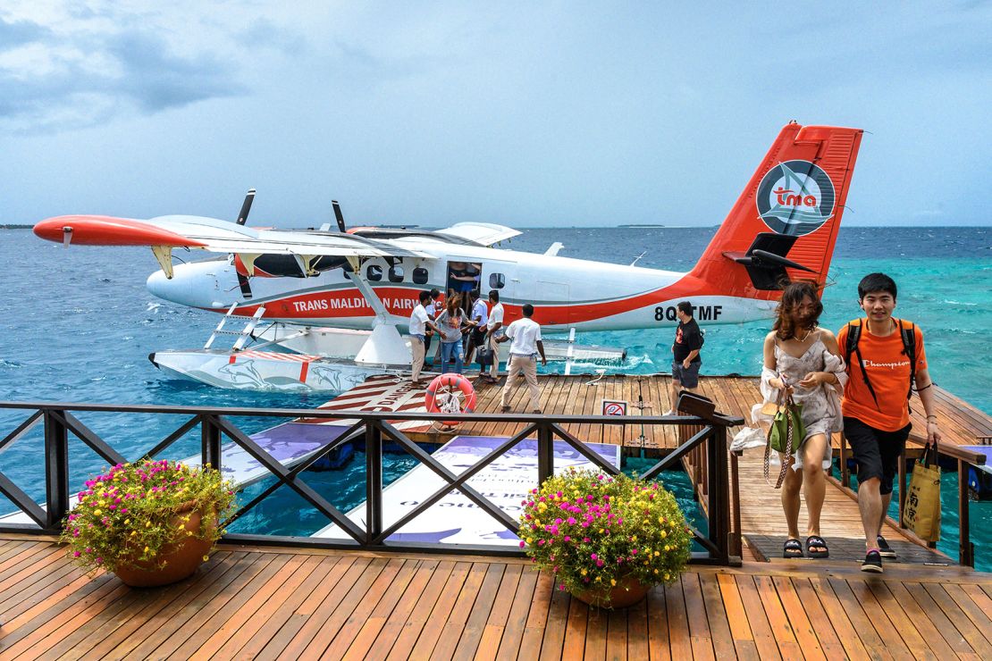 In this photograph taken on September 24, 2023, tourists disembark from a seaplane at a resort in Baa Atoll in Maldives.