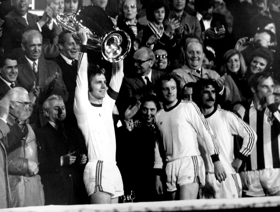 (L-R) Bayern Munich captain Franz Beckenbauer lifts the European Cup following his team's 4-0 victory, as teammates Johnny Hansen and Gerd Muller watch the reaction of the Bayern fans  (Photo by S&G/PA Images via Getty Images)