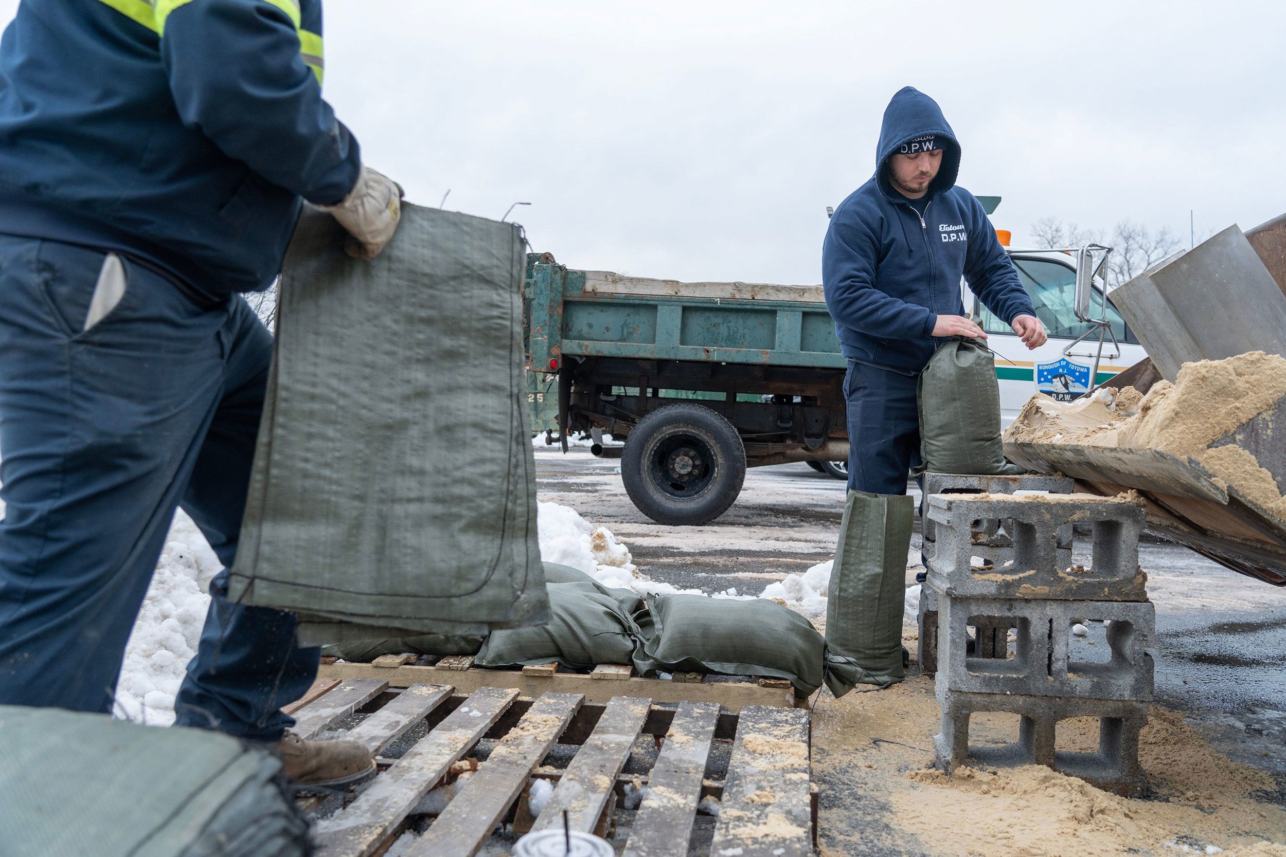 Workers Brian Henderson and Josko Huljev fill sandbags for residents of Totowa, New Jersey, on Tuesday. New Jersey Gov. Phil Murphy announced a state of emergency to prepare for the potentially dangerous weather. 