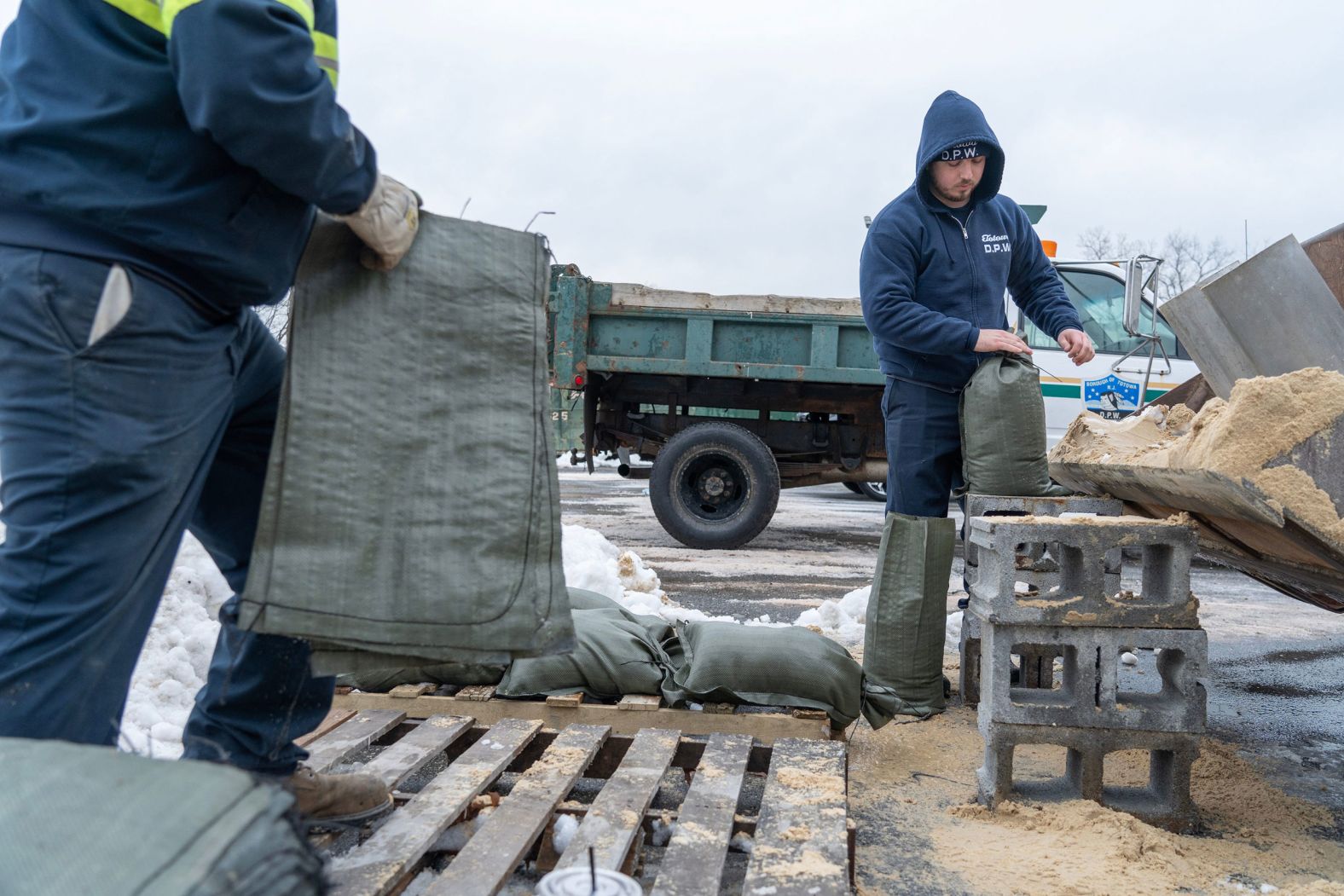 Workers Brian Henderson and Josko Huljev fill sandbags for residents of Totowa, New Jersey, on January 9. New Jersey Gov. Phil Murphy announced a state of emergency to prepare for the potentially dangerous weather.