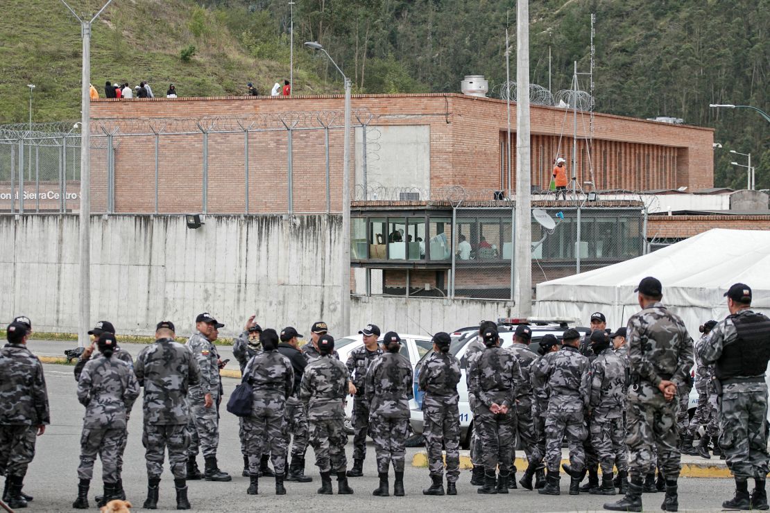 Police forces stand guard outside the Turi prison as inmates hold prison guards hostage, in Cuenca, Ecuador, on January 8, 2024. The leader of Ecuador's main criminal gang Adolfo Macías, alias "Fito", is thought to have escaped on January 7 "hours before" an operation at the prison where he was serving his sentence, Communication Secretary General Roberto Izurieta said on Monday. Following the escape of the head of the Los Choneros drug gang, incidents were reported in several of the country's prisons. (Photo by Fernando MACHADO / AFP)