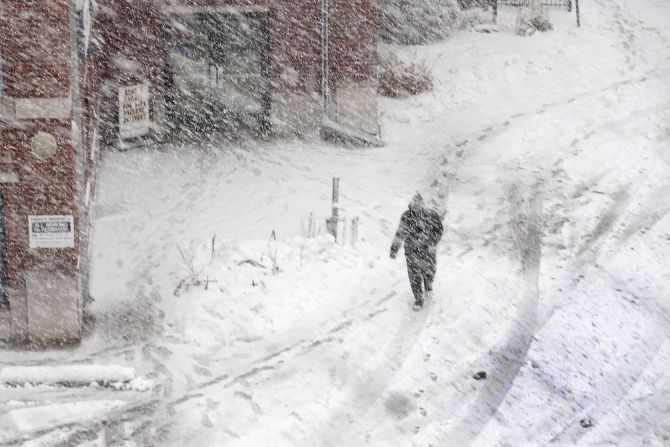 A pedestrian navigates a snow-covered sidewalk in Iowa City, Iowa, on January 9.