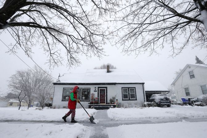 Kelly-Jo St. Aubin clears snow from the sidewalk outside her home in Kaukauna, Wisconsin, on January 9.