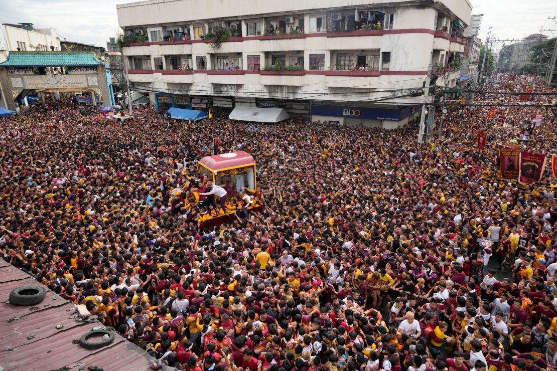 Devotees gather around the glass-covered cart carrying Black Nazarene during its annual procession which was resumed after a three-year suspension due to the coronavirus pandemic on Tuesday, Jan. 9, 2024 in Manila, Philippines. A mammoth crowd of mostly barefoot Catholic devotees joined a chaotic procession through downtown Manila Tuesday to venerate a centuries-old black statue of Jesus Christ with many praying for peace in the Middle East where Filipino relatives work. (AP Photo/Aaron Favila)