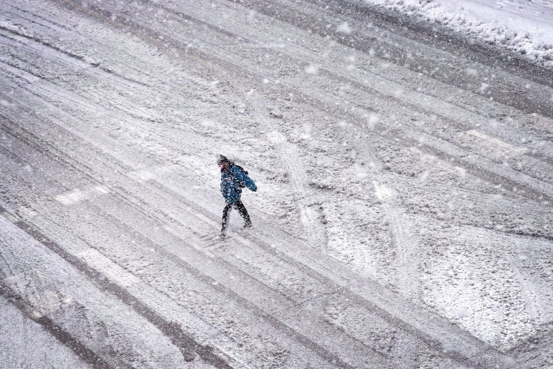 IOWA CITY, IOWA - JANUARY 09: A pedestrian navigates a snow-covered street on January 09, 2024 in Iowa City, Iowa. A winter storm cutting through the state is expected to dump up to 14 inches of snow on the city before winds, up to 40 MPH, come through on the backside of the storm. (Photo by Scott Olson/Getty Images)