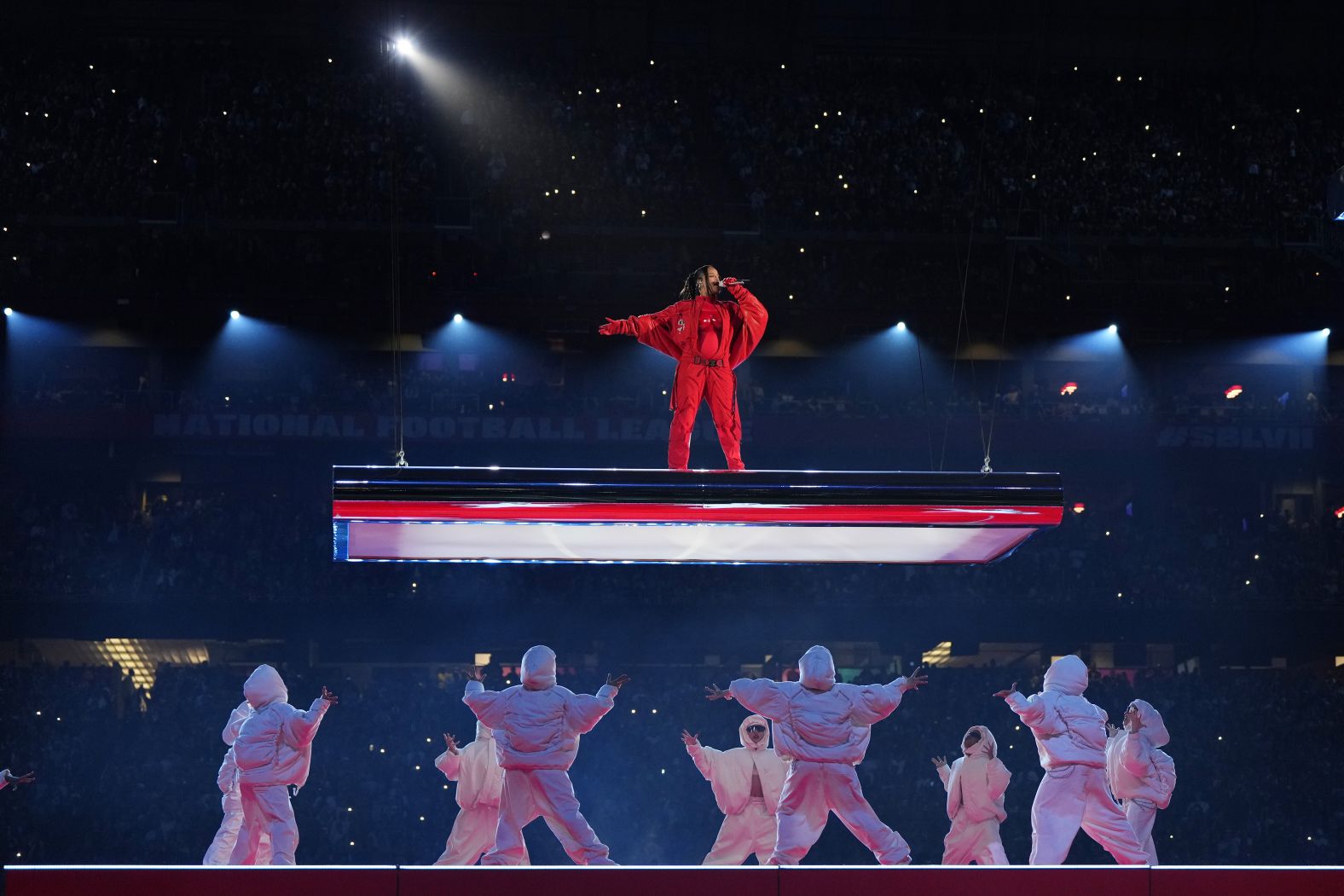 Rihanna performs during the Super Bowl halftime show in 2023. She opened the show by hanging high above the field on a platform. She rubbed her abdomen during her closing song, sparking speculation that she might be expecting. After the performance, a Rihanna representative confirmed that she was pregnant.