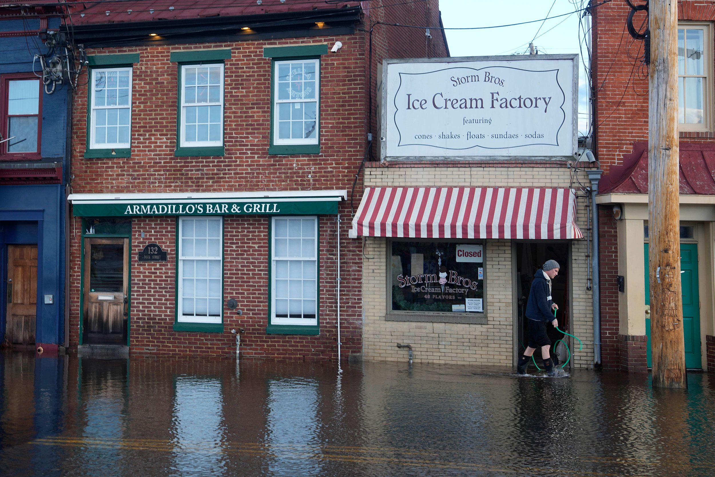 An employee of the Storm Bros. Ice Cream begins to clean up Wednesday after the storm left more than 2 feet of water inside many businesses in downtown Annapolis, Maryland.