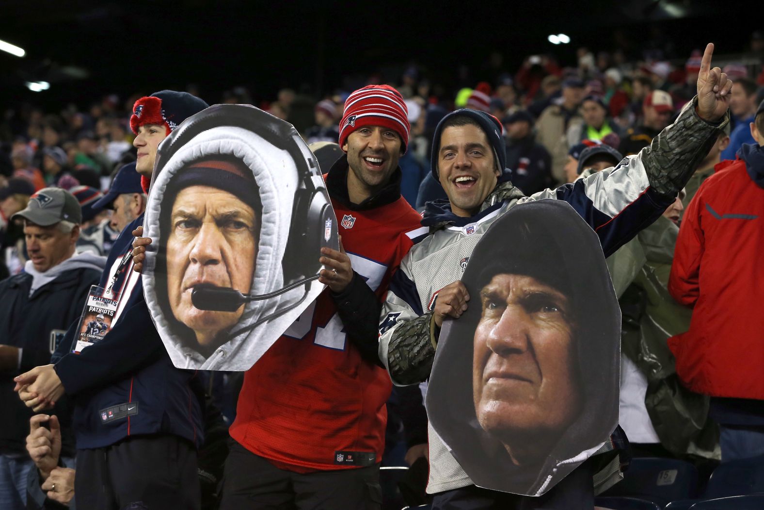 Patriots fans hold cutouts of Belichick's face before the AFC Championship Game in 2015.