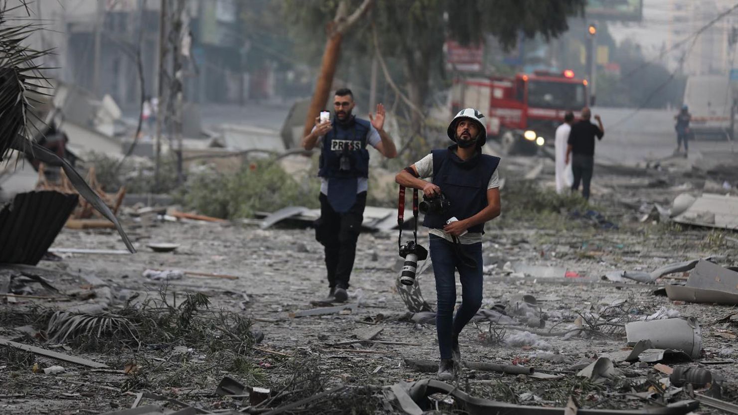 Journalists, who have risked their lives to cover the bombings in Gaza, walk through an area destroyed by Israel air strikes. Gaza City. Palestine. December 2023. (Photo by: Mohammed Al-Zanoun/Majority World/Universal Images Group via Getty Images)