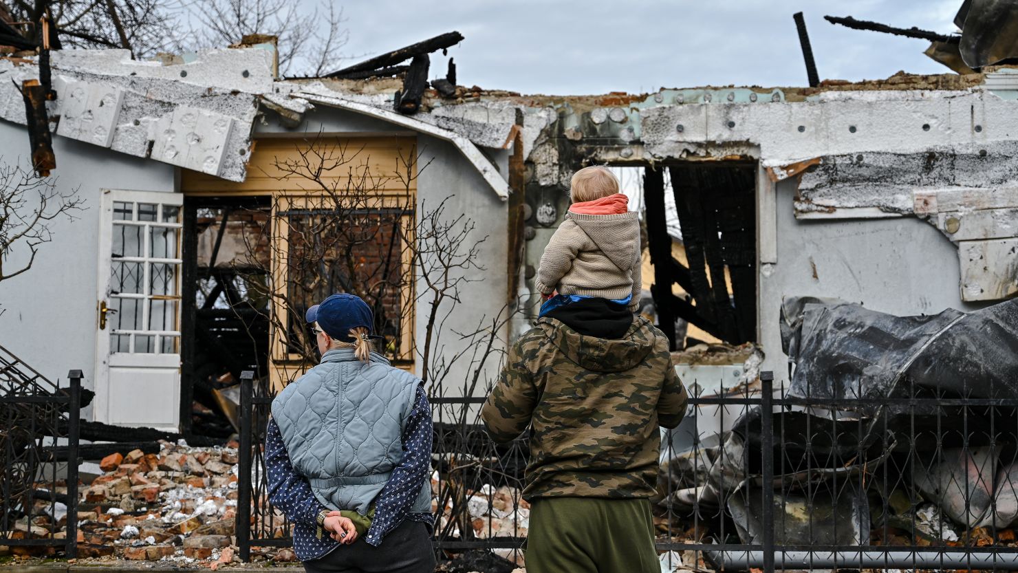 A woman and a man, with a boy on his shoulders, are looking at the ruins of the museum of Roman Shukhevych, the military leader of the Ukrainian Insurgent Army (UPA), following a Russian drone attack in Bilohorshcha on the outskirts of Lviv, Western Ukraine, on January 1, 2024. Preliminary reports indicate that 10 Russian Shahed drones attacked the Lviv community on New Year's Eve, with falling debris from a Russian drone causing a fire at the Shukhevych Museum. NO USE RUSSIA. NO USE BELARUS. (Photo by Ukrinform/NurPhoto via Getty Images)