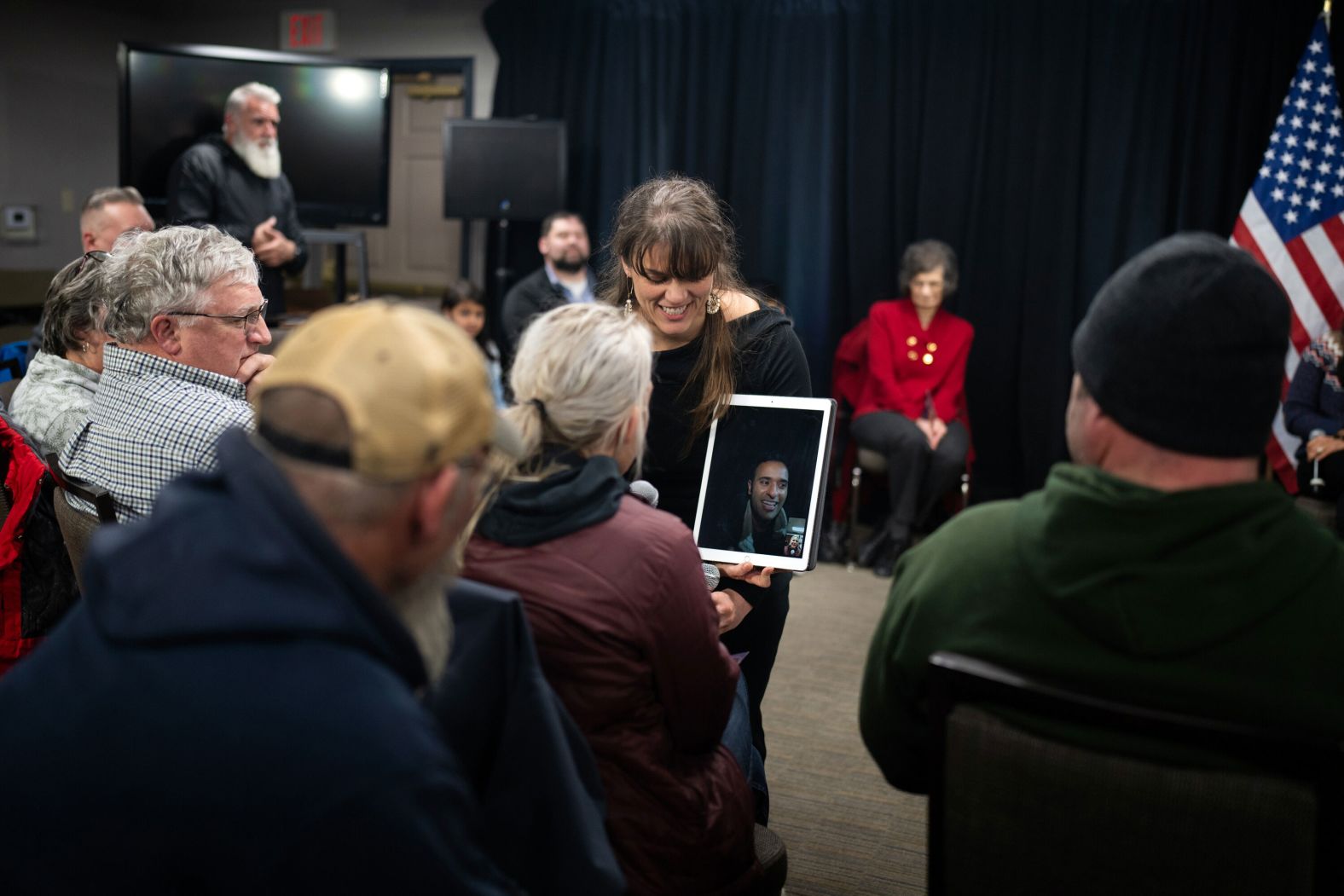 Republican presidential candidate Vivek Ramaswamy, appearing via video on a tablet, speaks to a potential voter at a campaign event in Pella, Iowa, on Tuesday, January 8. Ramaswamy was unable to attend the event in person because of snow-covered roads in the area. 