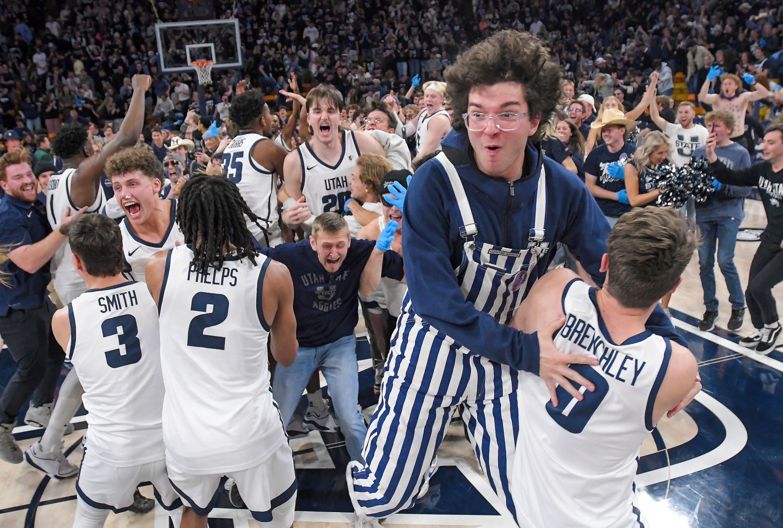Utah State players celebrate with fans after the team's college basketball win over Colorado State on Saturday, January 6.