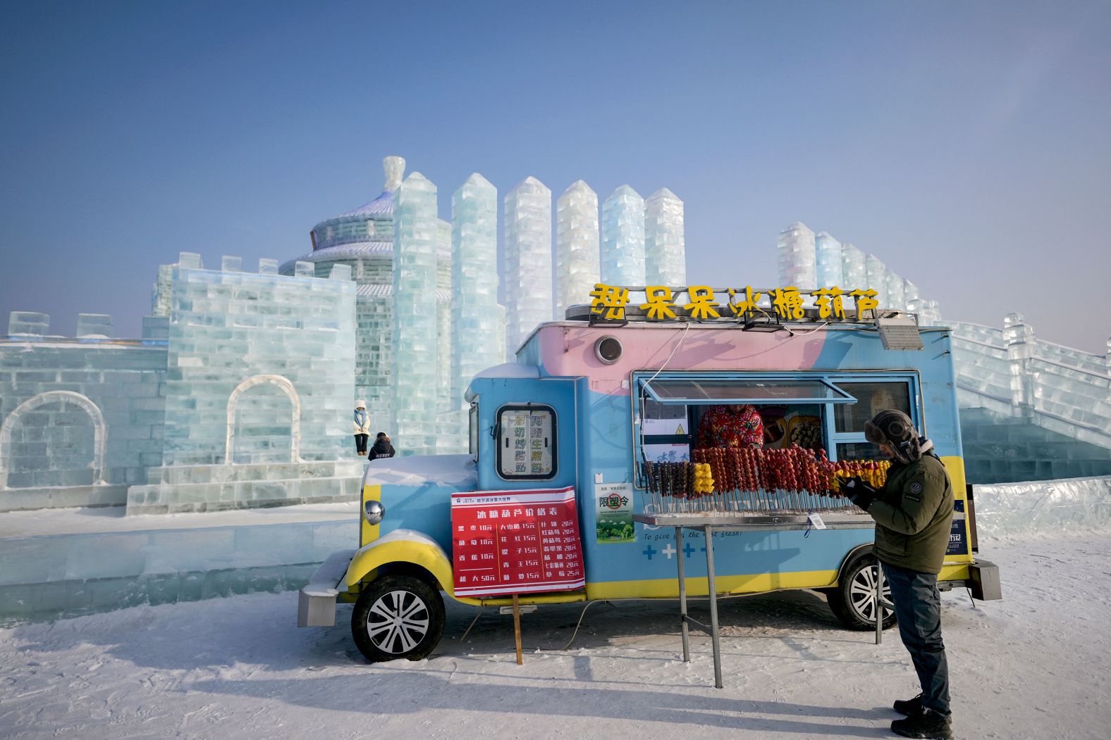 A man stands beside a food van Friday, January 5, at the Harbin Ice and Snow World in Harbin, China.