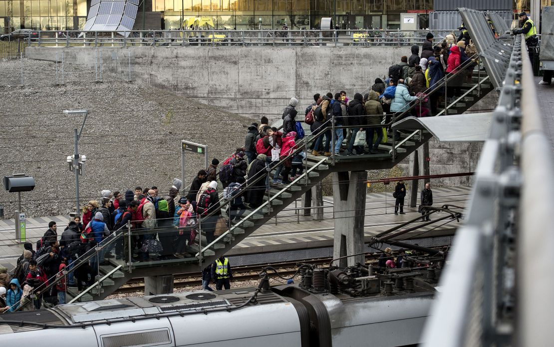 Police organize the line of refugees on the stairway leading up from the trains arriving from Denmark at the Hyllie train station outside Malmo, Sweden, November 19, 2015. 600 refugees arrived in Malmo within 3 hours and the Swedish Migration Agency said in a press statement that they no longer can guarantee accommodation for all asylum seekers.     AFP PHOTO / TT NEWS AGENCY / JOHAN NILSSON    +++   SWEDEN OUT   +++        (Photo credit should read JOHAN NILSSON/AFP via Getty Images)