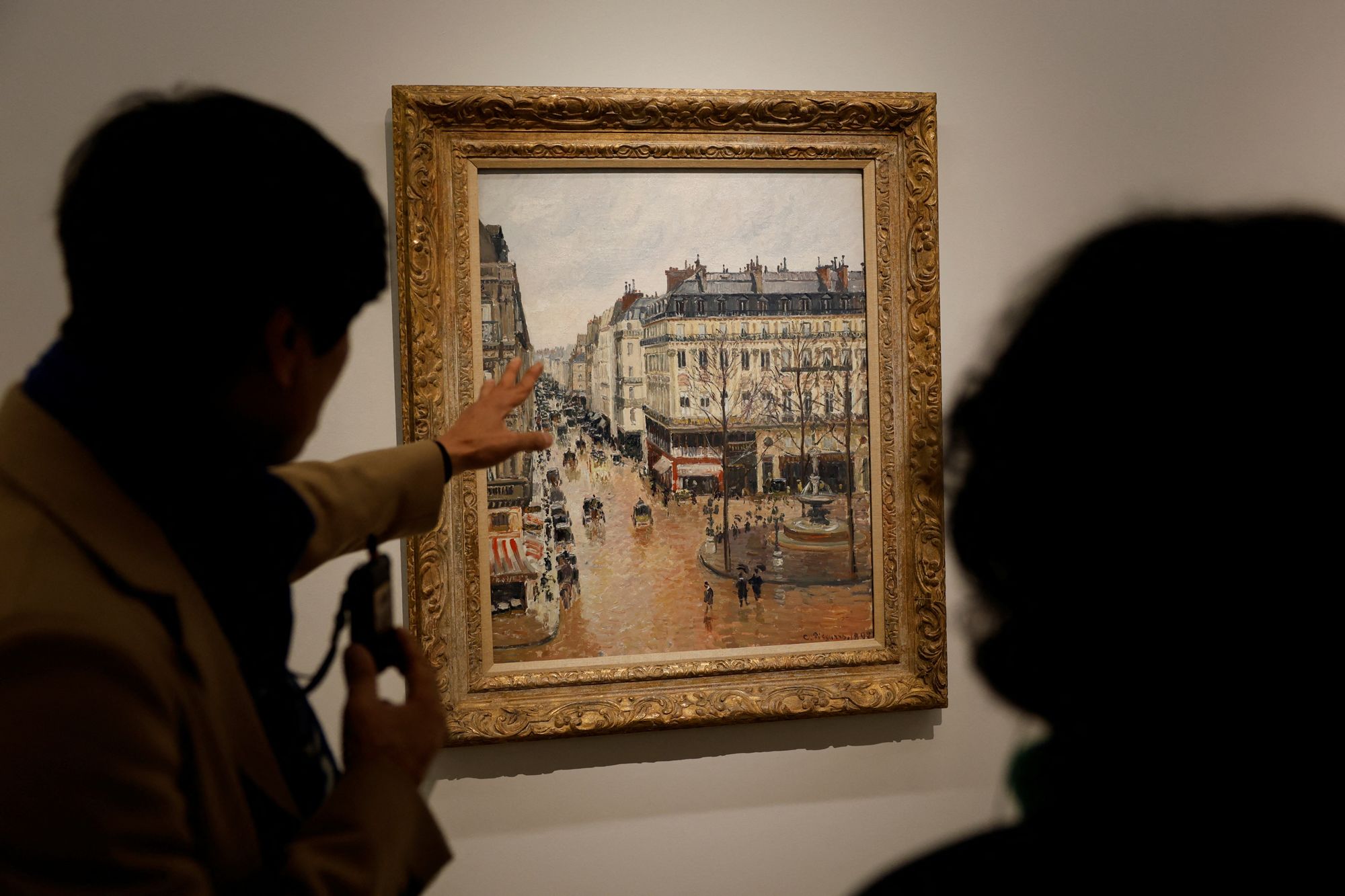 A museum guide speaks about Camille Pissarro's 1897 "Rue Saint-Honore in the Afternoon. Effect of Rain" at Thyssen-Bornemisza museum in Madrid, Spain, January 10, 2024. REUTERS/Susana Vera