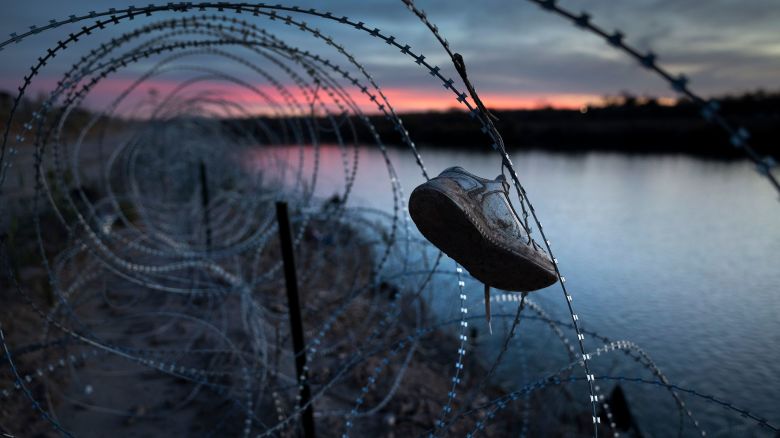 EAGLE PASS, TEXAS - JANUARY 09: A child's shoe hangs caught in razor wire atop the bank of the Rio Grande on January 9, 2024 in Eagle Pass, Texas. Following a major surge of migrant border crossings late last year, large quantities of refuse left behind by migrants as well as miles of razor wire installed by Texas National Guard troops remain along the U.S.-Mexico border at Eagle Pass. (Photo by John Moore/Getty Images)