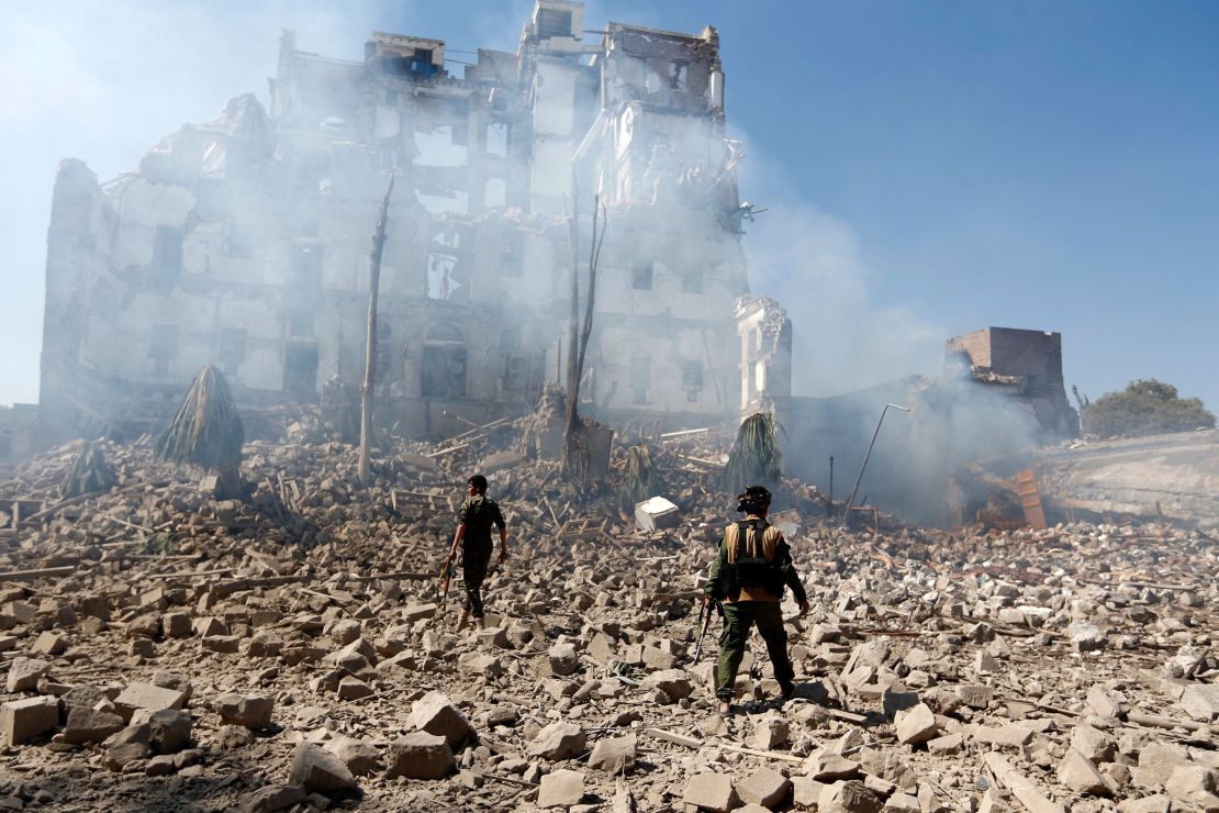 TOPSHOT - Huthi rebel fighters inspect the damage after a reported air strike carried out by the Saudi-led coalition targeted the presidential palace in the Yemeni capital Sanaa on December 5, 2017. Saudi-led warplanes pounded the rebel-held capital before dawn after the rebels killed former president Ali Abdullah Saleh as he fled the city following the collapse of their uneasy alliance, residents said. (Photo by Mohammed HUWAIS / AFP) (Photo by MOHAMMED HUWAIS/AFP via Getty Images)