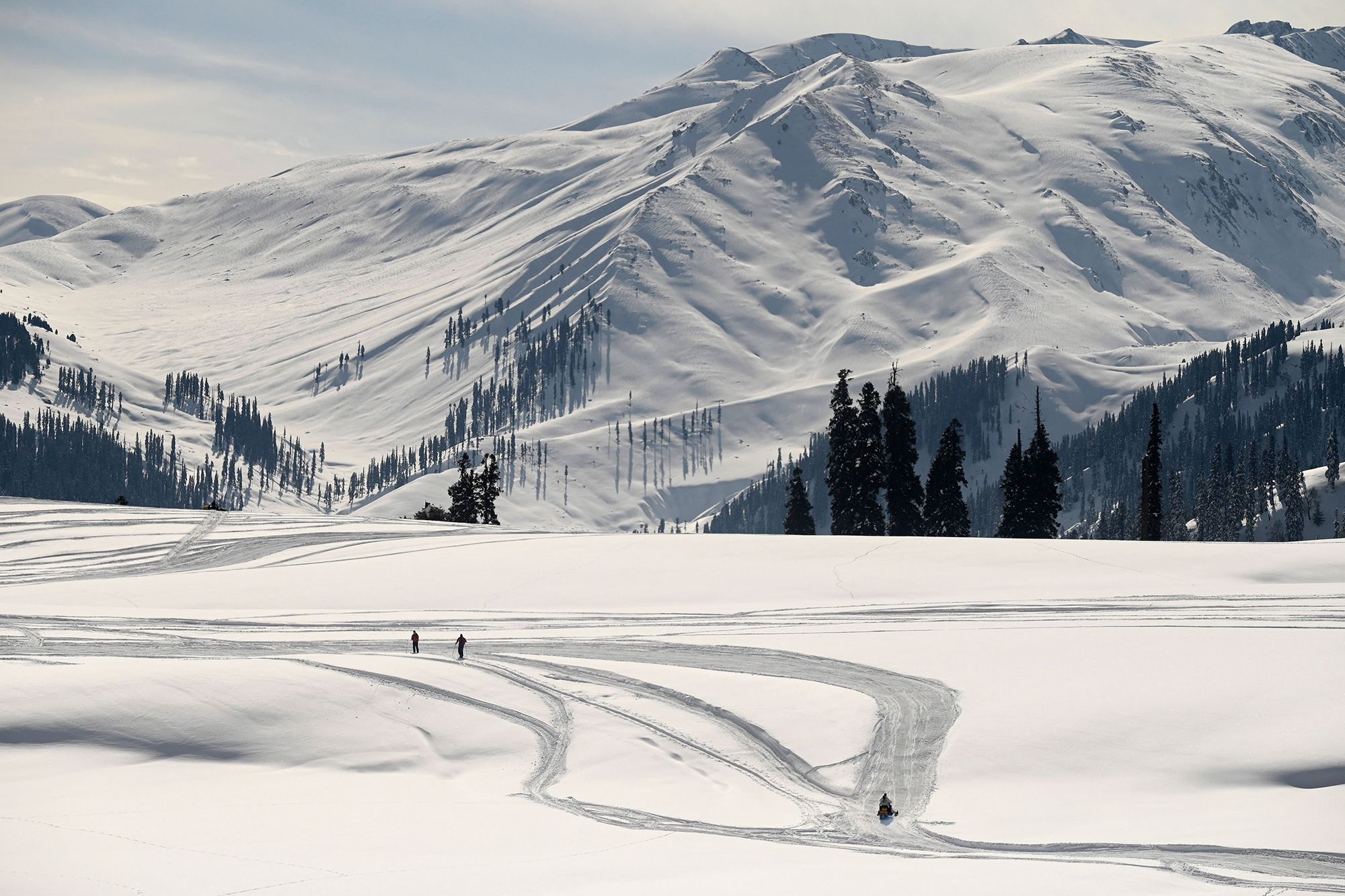 Skiers walks towards a slope at a ski resort in Kangdori, Gulmarg in Srinagar on February 2, 2023. - Two Polish nationals were killed and 21 other skiers were rescued from the site of an avalanche that hit the Indian resort of Gulmarg on February 1, 2023, police said. (Photo by TAUSEEF MUSTAFA / AFP) (Photo by TAUSEEF MUSTAFA/AFP via Getty Images)