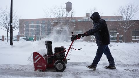 A man clears snow off a sidewalk Friday, Jan. 12, 2024, in Des Moines, Iowa.