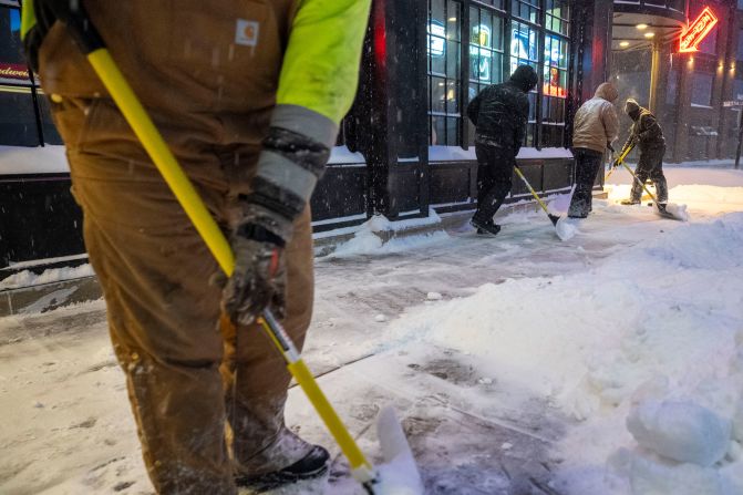 Workers shovel sidewalks in Ankeny, Iowa, on January 12. The vast majority of Iowa was under a blizzard warning.