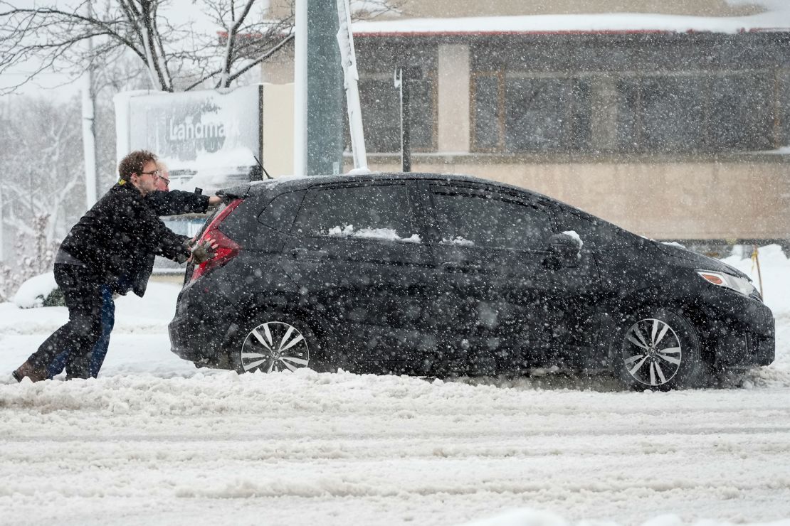 People push a car out of a snowbank as a winter storm arrives Friday, Jan. 12, 2024, in West Allis, Wis. (AP Photo/Morry Gash)