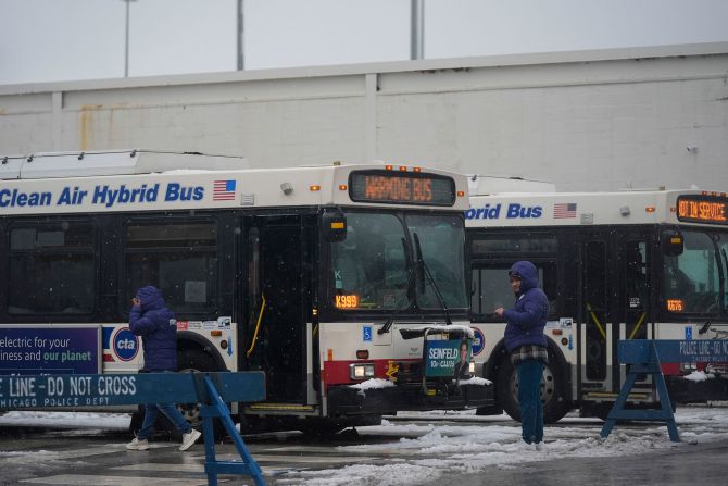 Snow falls on January 12 as migrants in Chicago continue to be housed by the city in "warming" buses.