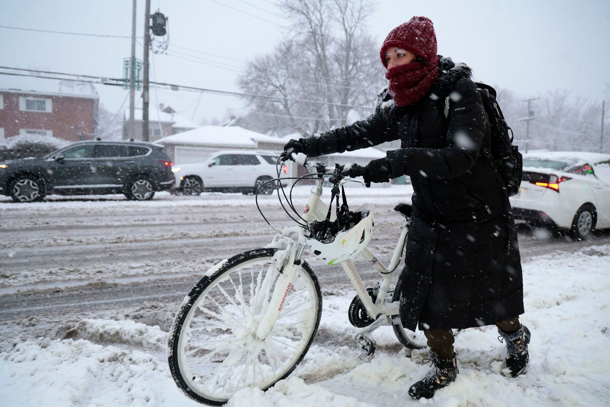 Rebecca Zimmerman walks beside her bicycle on her way to work in Oak Park, Illinois, on Friday.