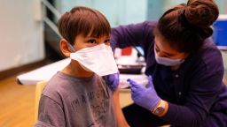 Ephrem Chen, 9, receives his COVID-19 booster shot and a flu vaccine from an IDPH nurse during a walk-in clinic on Dec. 3, 2023, at St. Procopius School in the Pilsen neighborhood of Chicago. (Brian Cassella/Chicago Tribune/Tribune News Service via Getty Images)