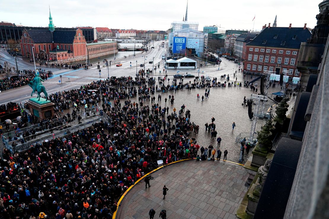 People gather at the Christiansborg Castle square in Copenhagen, Denmark, Sunday, Jan. 14 2024. Denmark's Crown Prince Frederik takes over the crown on Sunday from his mother, Queen Margrethe II, who is breaking with centuries of Danish royal tradition and retiring after a 52-year reign.