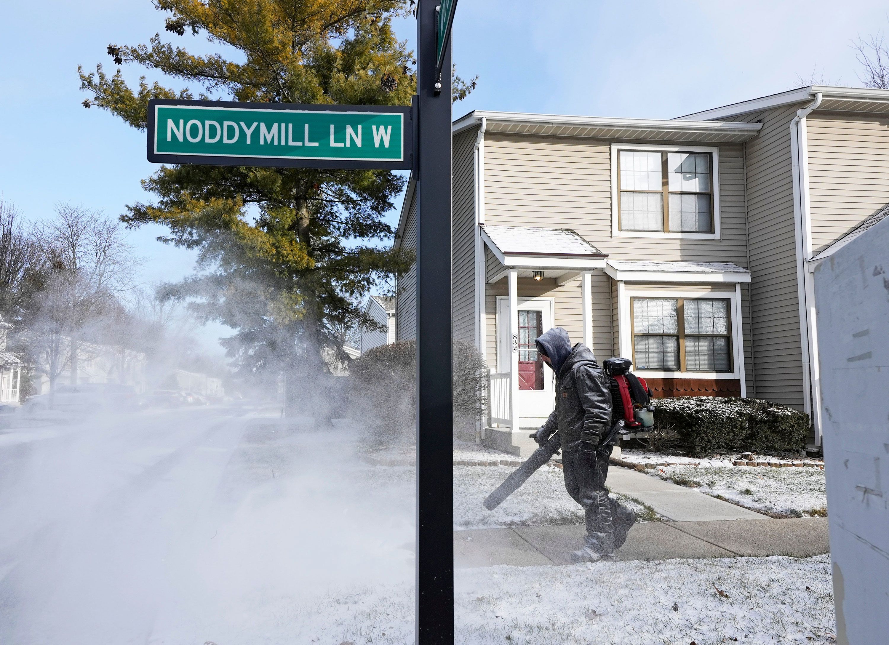 A person clears a sidewalk in front of condominiums in Worthington, Ohio, on Sunday.