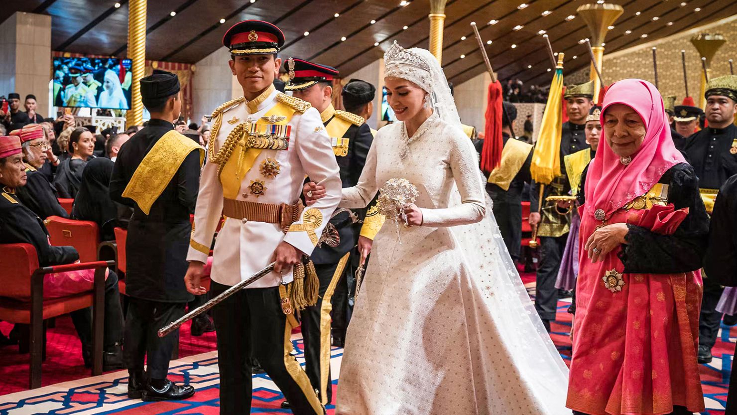 Prince Abdul Mateen (L) and Yang Mulia Anisha Rosnah walk down the aisle during their wedding reception at Istana Nurul Iman in Brunei's capital Bandar Seri Begawan on January 14, 2024. Lavish celebrations for the wedding of Brunei's Prince Abdul Mateen and his wife reached a climax on January 14 with a glittering ceremony attended by government leaders and blue-blooded guests from Asia and the Middle East.