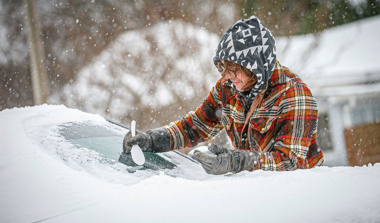 Daniel Cole uses a plastic spoon to clear ice from his vehicle in Florence, Alabama, on January 15.
