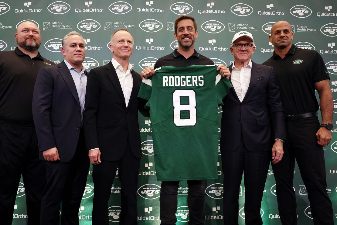 FLORHAM PARK, NEW JERSEY - APRIL 26: (L-R) New York Jets general manager Joe Douglas, team president Hymie Elhai, team owner Christopher Johnson, quarterback Aaron Rodgers, team owner Woody Johnson, and head coach Robert Saleh pose during an introductory press conference at Atlantic Health Jets Training Center on April 26, 2023 in Florham Park, New Jersey. (Photo by Elsa/Getty Images)