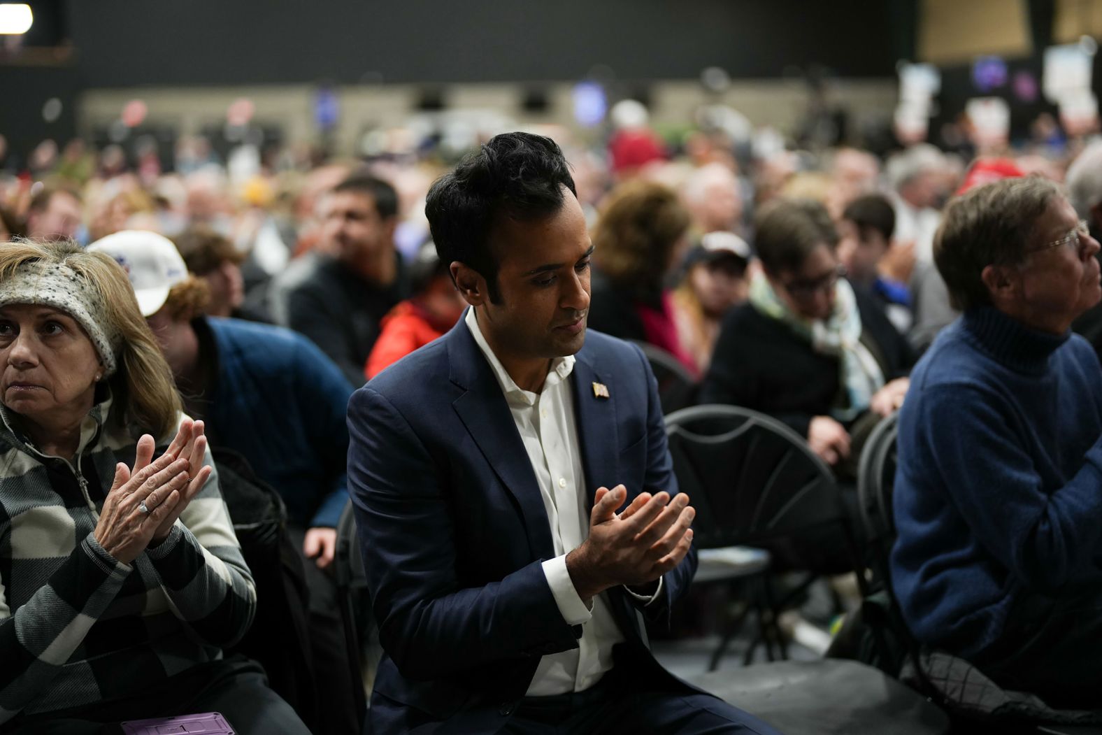 Ramaswamy claps as former President Donald Trump speaks to caucusgoers in Clive, Iowa, in January 2024. Ramaswamy suspended his campaign after the Iowa caucuses and endorsed Trump.