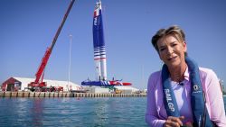 CNN's Becky Anderson at the Abu Dhabi Sail Grand Prix while an F50 catamaran is winched into the water behind her. 