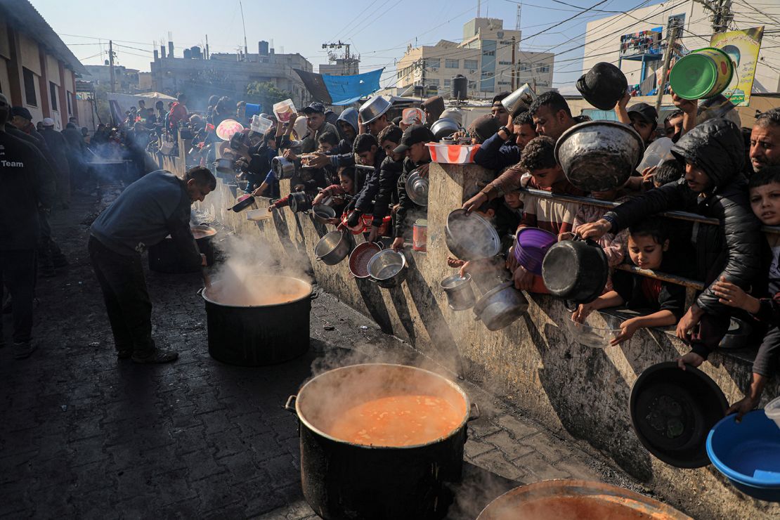 People wait for food relief in the southern Gaza Strip city of Rafah, on December 31, 2023.