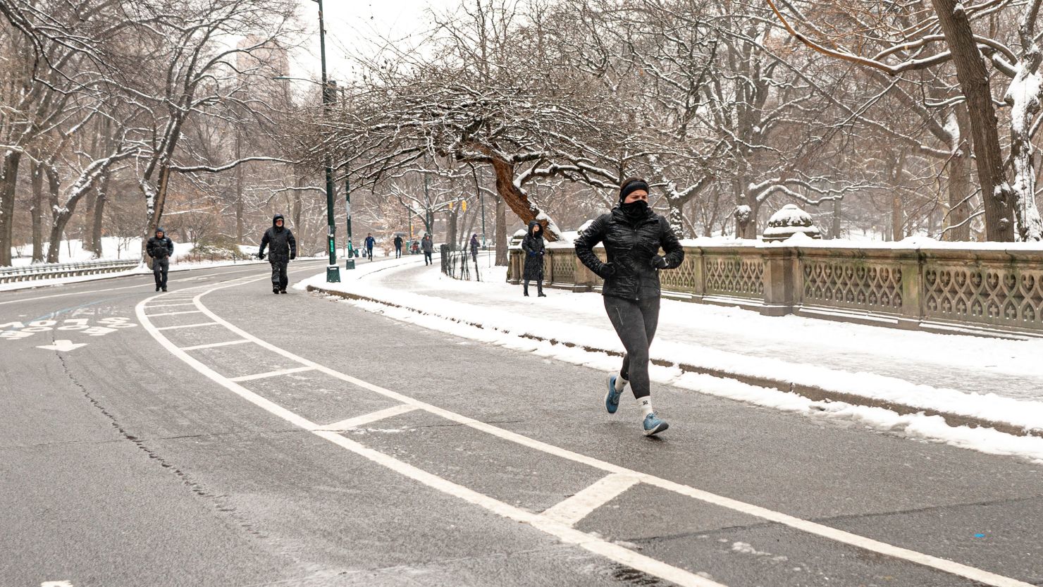 A woman jogs in the snow in Central Park, Tuesday, Jan. 16, 2024, in New York. (AP Photo/Peter K. Afriyie)