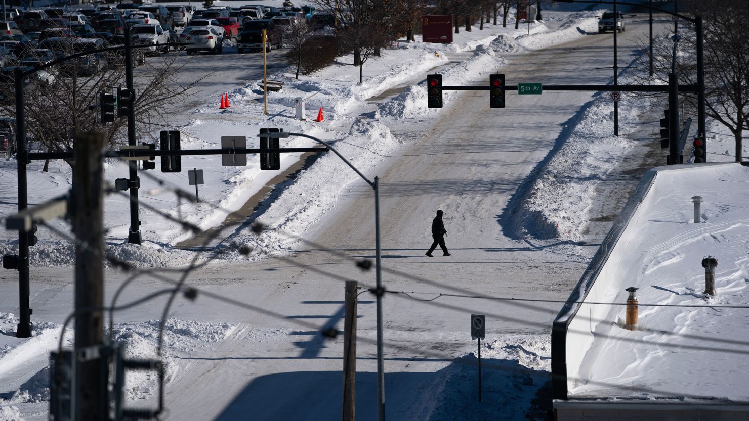 A pedestrian crosses a snow-covered street during a winter storm ahead of the Iowa caucus in Des Moines, Iowa, US, on Sunday, Jan. 14, 2024. Iowans on Monday will cast the first votes in the 2024 presidential nominating process during a caucus that's likely to show depressed turnout because of historically frigid weather. Photographer: Nathan Howard/Bloomberg via Getty Images