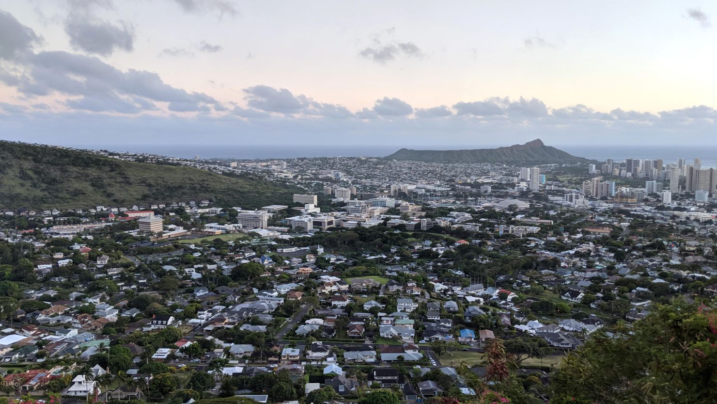 Diamondhead and the city of Honolulu, Kaimuki, Kahala, and oceanscape on Oahu on a nice day at dusk viewed from high in the mountains with tall trees