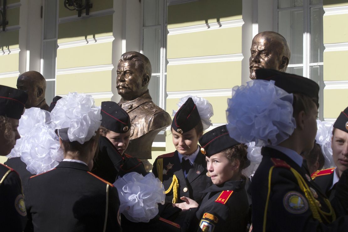 Students of a military-sponsored school attend the opening of a series of Russian leaders, including Vladimir Lenin, background right, and Josef Stalin, background center, in Moscow, Russia, Friday, Sept. 22, 2017. The Russian Military-Historic Society, an organization founded by President Vladimir Putin and led by his culture minister, unveiled the sculptures Friday to expand its "alley of rulers" at a Moscow park, which until now had featured busts of Russian monarchs. It described the new display as part of efforts to preserve Russian history. (AP Photo/Alexander Zemlianichenko)