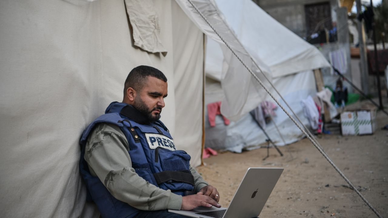 RAFAH, GAZA - JANUARY 14: A press member is seen sitting next to a tent as he tries to connect to the internet while he and his colleagues in Gaza face high risks trying to cover the Israel-Gaza war on January 14, 2024 in Rafah, Gaza. Israeli forces are dropping phosphorus bombs from the sky on people in the besieged Gaza Strip while prohibiting journalists from entering military zones. Nevertheless, photos taken by journalists was later used as clear evidence of Israel's use of phosphorus bombs in Gaza. Journalists who took shelter in Rafah due to the Israeli attacks are trying to provide food and supplies for their families, while also struggling to show what is really happening in Gaza to the world. (Photo by Abed Zagout/Anadolu via Getty Images)