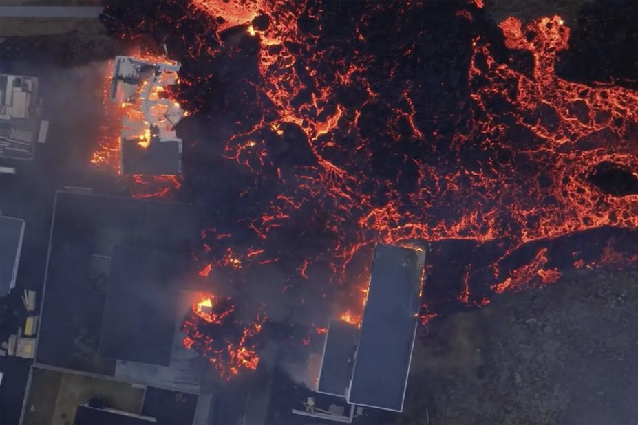 Molten lava flows over houses in Grindavik, Iceland, on Sunday, January 14, after <a href="https://www.cnn.com/2024/01/13/europe/iceland-volcanic-evacuation-grindavik-intl-hnk/index.html" target="_blank">a volcano erupted</a>. Grindavík was previously evacuated following weeks of seismic activity which culminated in a dramatic volcanic eruption that expelled bursts of lava and sent huge plumes of smoke into the sky.