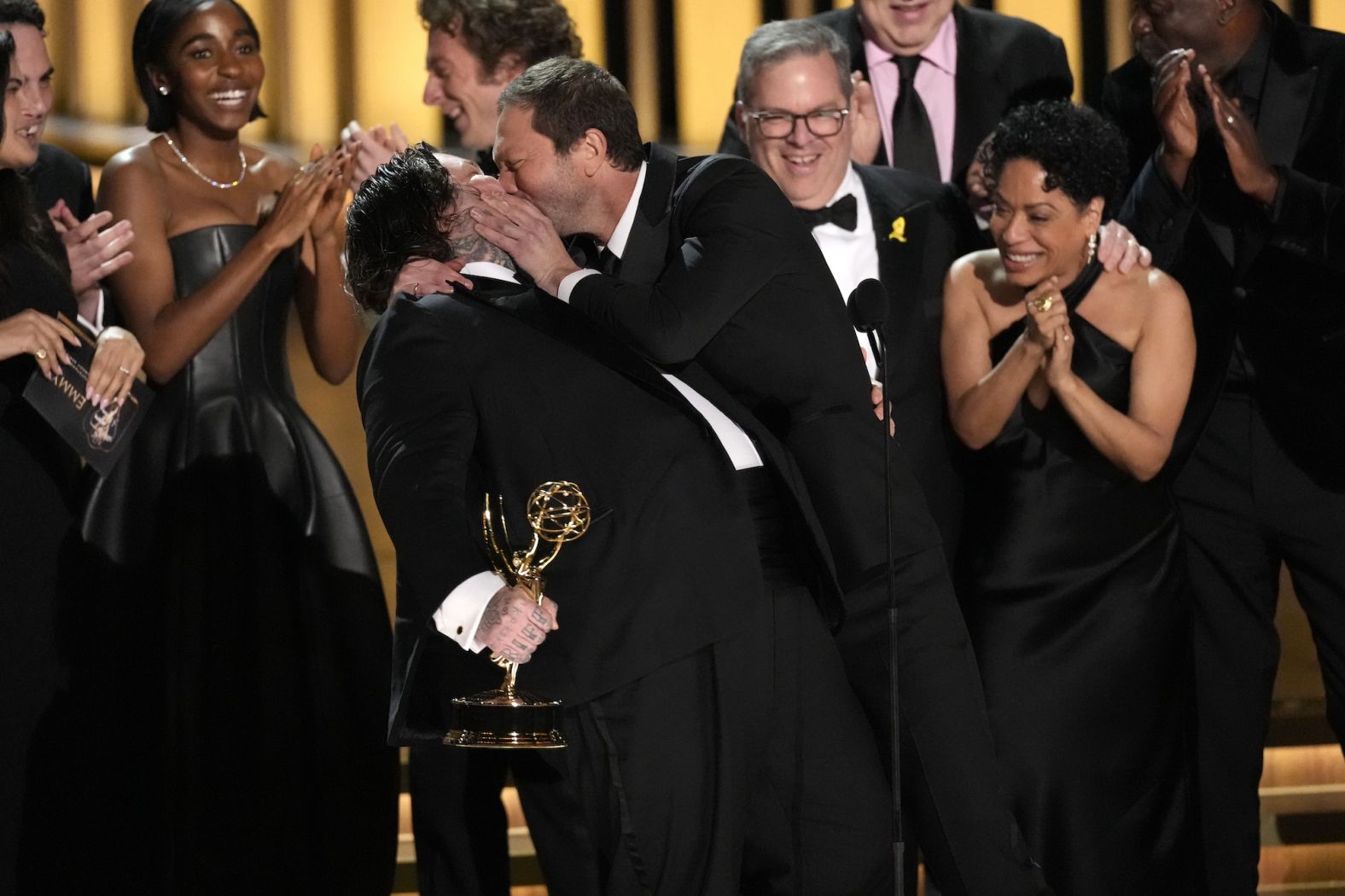 Matty Matheson, left, is kissed by co-star Ebon Moss-Bachrach after "The Bear" won the <a href="index.php?page=&url=https%3A%2F%2Fwww.cnn.com%2F2024%2F01%2F15%2Fentertainment%2Ftakeaways-emmy-awards%2Findex.html" target="_blank">Emmy Award</a> for outstanding comedy series on Monday, January 15. <a href="index.php?page=&url=https%3A%2F%2Fwww.cnn.com%2F2024%2F01%2F15%2Fentertainment%2Fgallery%2F75th-emmy-awards%2Findex.html" target="_blank">See more photos from the Emmy Awards</a>.