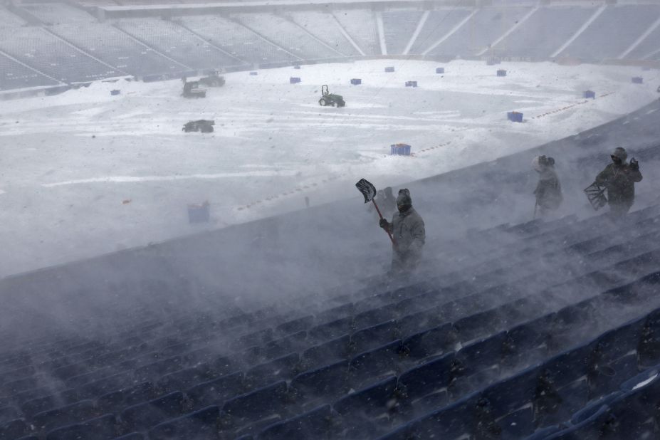 Workers remove snow from Highmark Stadium in Orchard Park, New York, on Sunday, January 14. Wild winter storm conditions prompted the NFL to delay the <a href="https://www.cnn.com/2024/01/15/sport/nfl-wild-card-monday-bills-steelers-bucs-eagles-preview-spt-intl/index.html" target="_blank">Buffalo Bills' wild-card game against the Pittsburgh Steelers</a> to Monday.