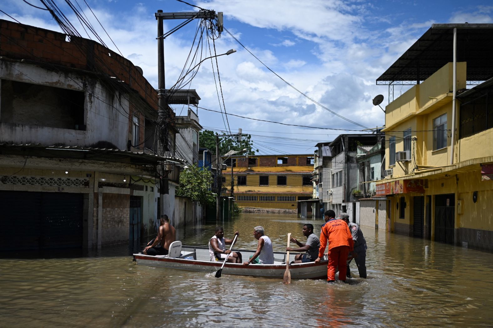 People paddle a boat in a flooded area of Belford Roxo, in Brazil's Rio de Janeiro state, on Monday, January 15.
